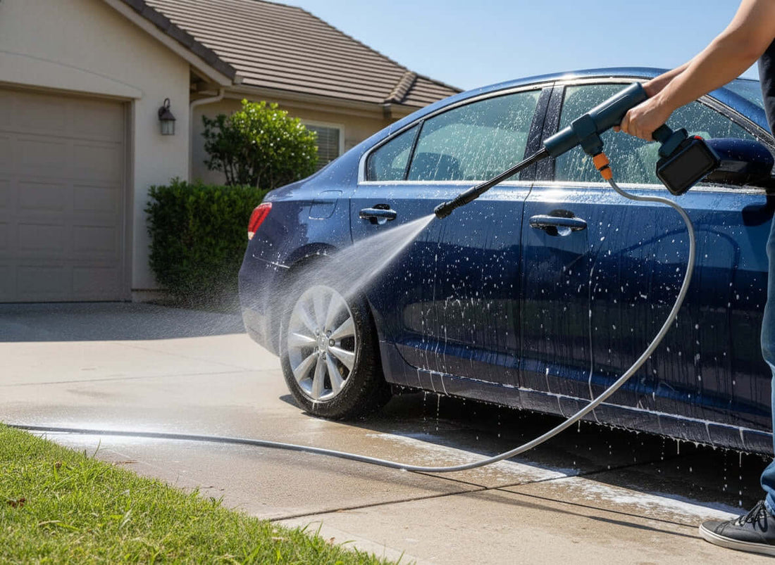 Portable cordless pressure washer cleaning a car outdoors with adjustable spray nozzle and flexible water hose.