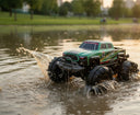 4WD amphibious remote control car performing a stunt on rough terrain near water